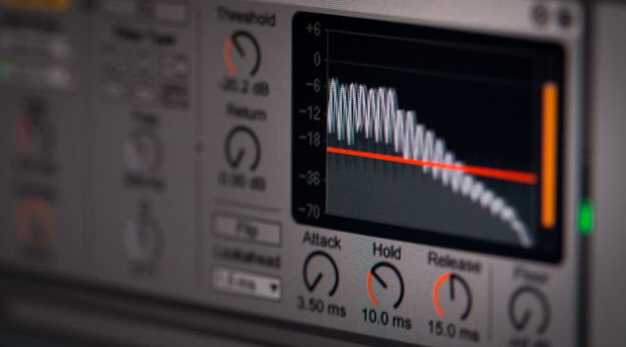 Close-up of an audio compressor plugin interface with waveform display and control knobs.