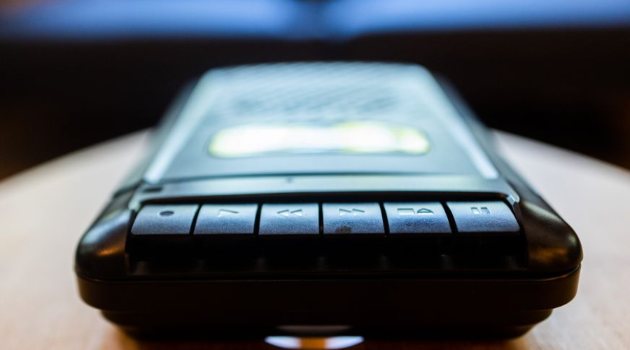 Close-up of a vintage cassette tape recorder on a wooden table.
