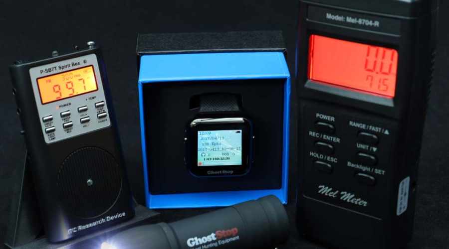 Light meter, sound level meter, smartwatch, and flashlight on a black background