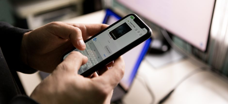 Person using a smartphone to browse a website in an office setting