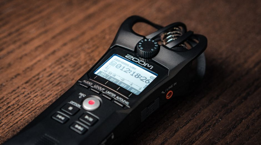 Close-up of a Zoom H4n Pro portable audio recorder on a wooden surface.