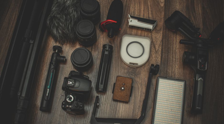 Flat lay of photography equipment and accessories on a wooden surface.