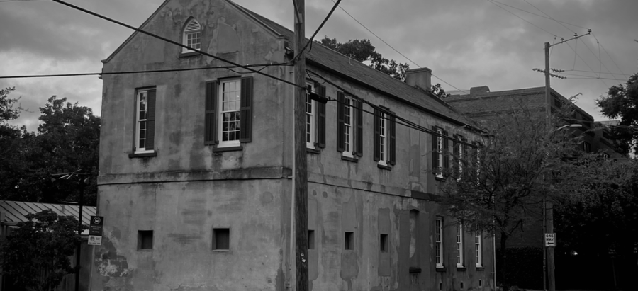 Black-and-white photo of the historic Sorrel Weed House on a corner, with power lines and a cloudy sky.