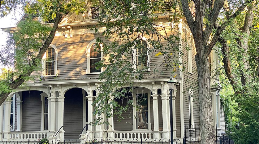 Joseph Forepaugh Mansion, a Victorian home with an ornate porch framed by lush trees in Saint Paul.
