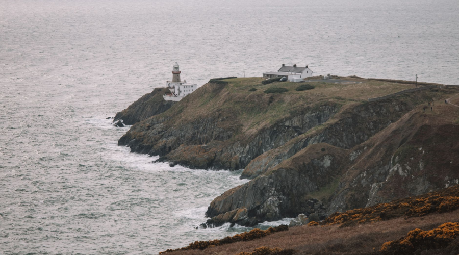 Baily Lighthouse on rocky cliffs above the ocean at Howth Head, Dublin