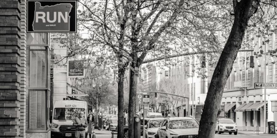 Black and white Portland street scene with RUN sign and parked cars