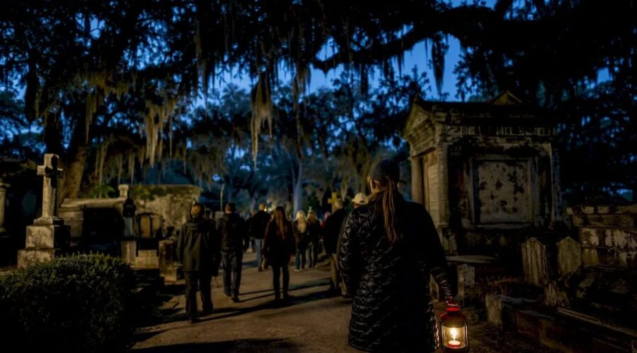 Illustration of a small lantern-lit group walking through a cemetery