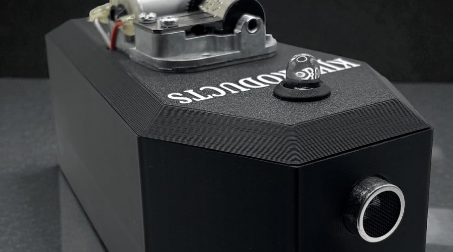 Black KJK Products paranormal music box with two front sensor openings and an exposed music mechanism.